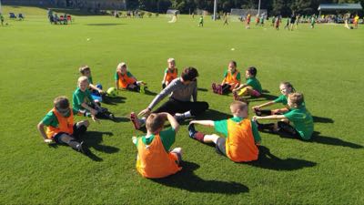 Camp group stretching in a circle with a coach