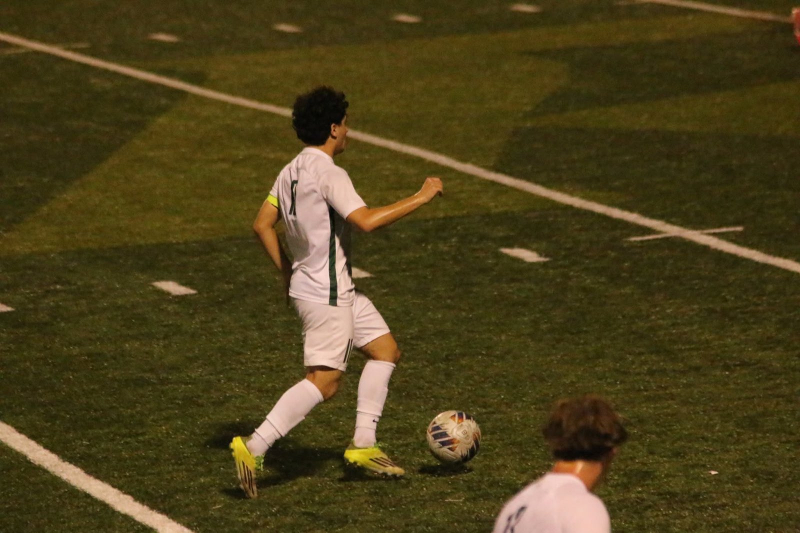 A Floyd Central player fights through a challenge at midfield in the away whites